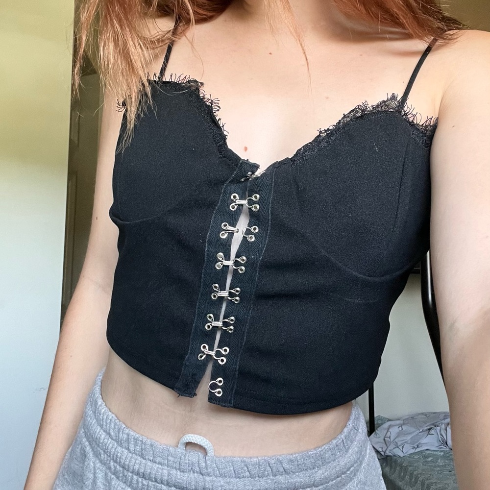 Black clip up the front bustier with fraying lace along the top. Size - L